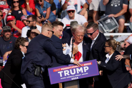 Donald Trump is assisted by U.S. Secret Service personnel after gunfire rang out during a campaign rally