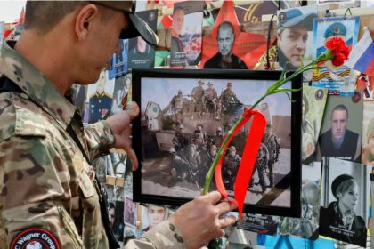 A man stands in front of a makeshift memorial erected following the 2023 deaths of the head of Russia's Wagner mercenary group Yevgeny Prigozhin