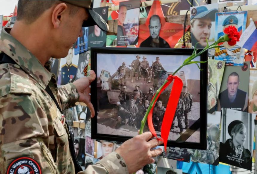 A man stands in front of a makeshift memorial erected following the 2023 deaths of the head of Russia's Wagner mercenary group Yevgeny Prigozhin