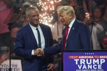 Robert F. Kennedy Jr. in a handshake with Donald Trump