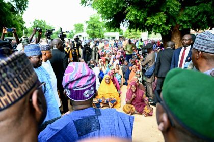 President Tinubu(backing camera) addressing flood victims