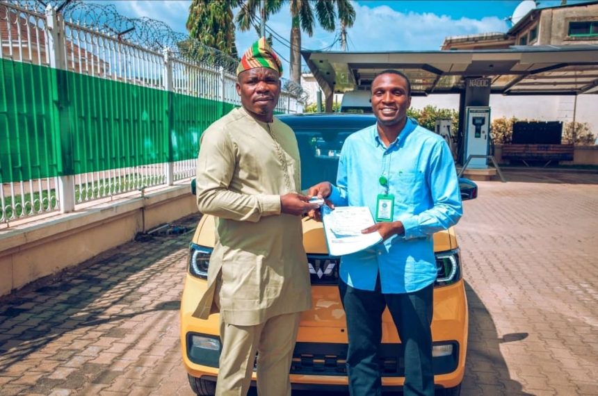 NACDC DG Joseph Osanipin presenting an electric car key in honour and copy of Memorandum of Understanding signed with Enoch Tobiloba, an HND ll student of Yabatech