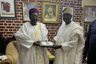 Sheu of Borno, His Royal Highness, (Dr.) Abubakar Garba Al-Amin El - Kanemi, presenting a gift to Rasaki Oladejo, FCS, President of Muslim Ummah of South West Nigeria